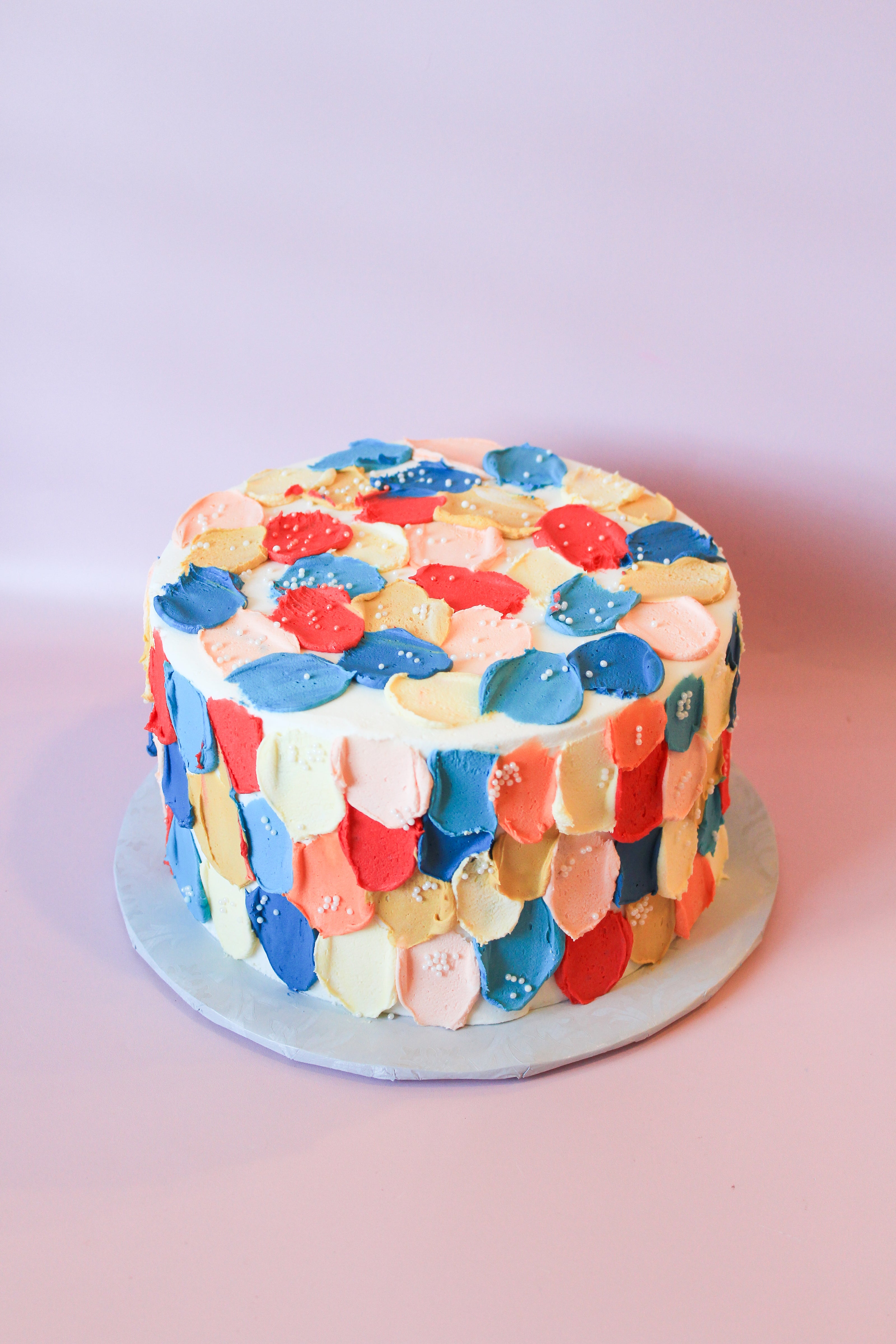Colorful patterned cake on a pink background