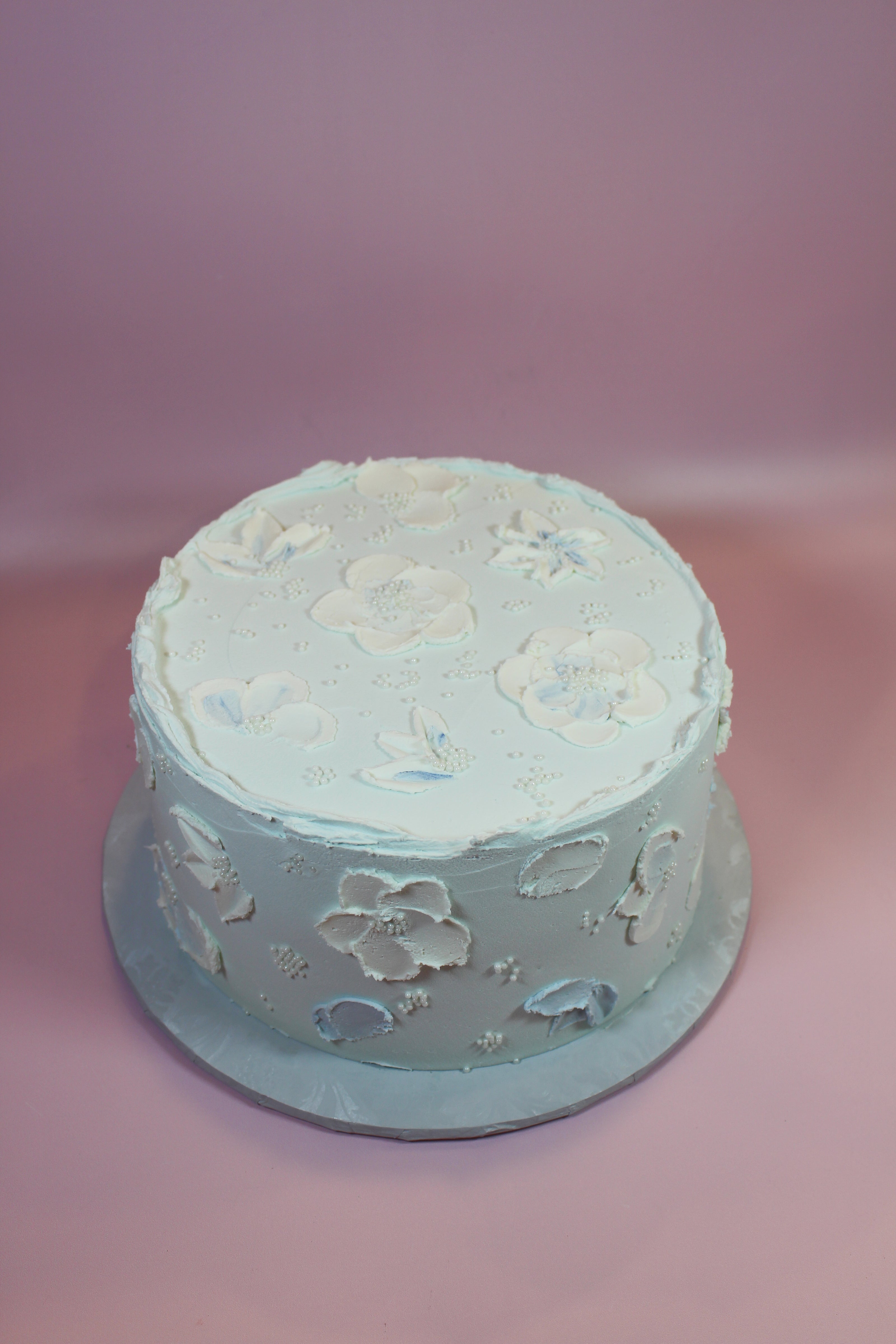Round cake with floral designs on a pink background