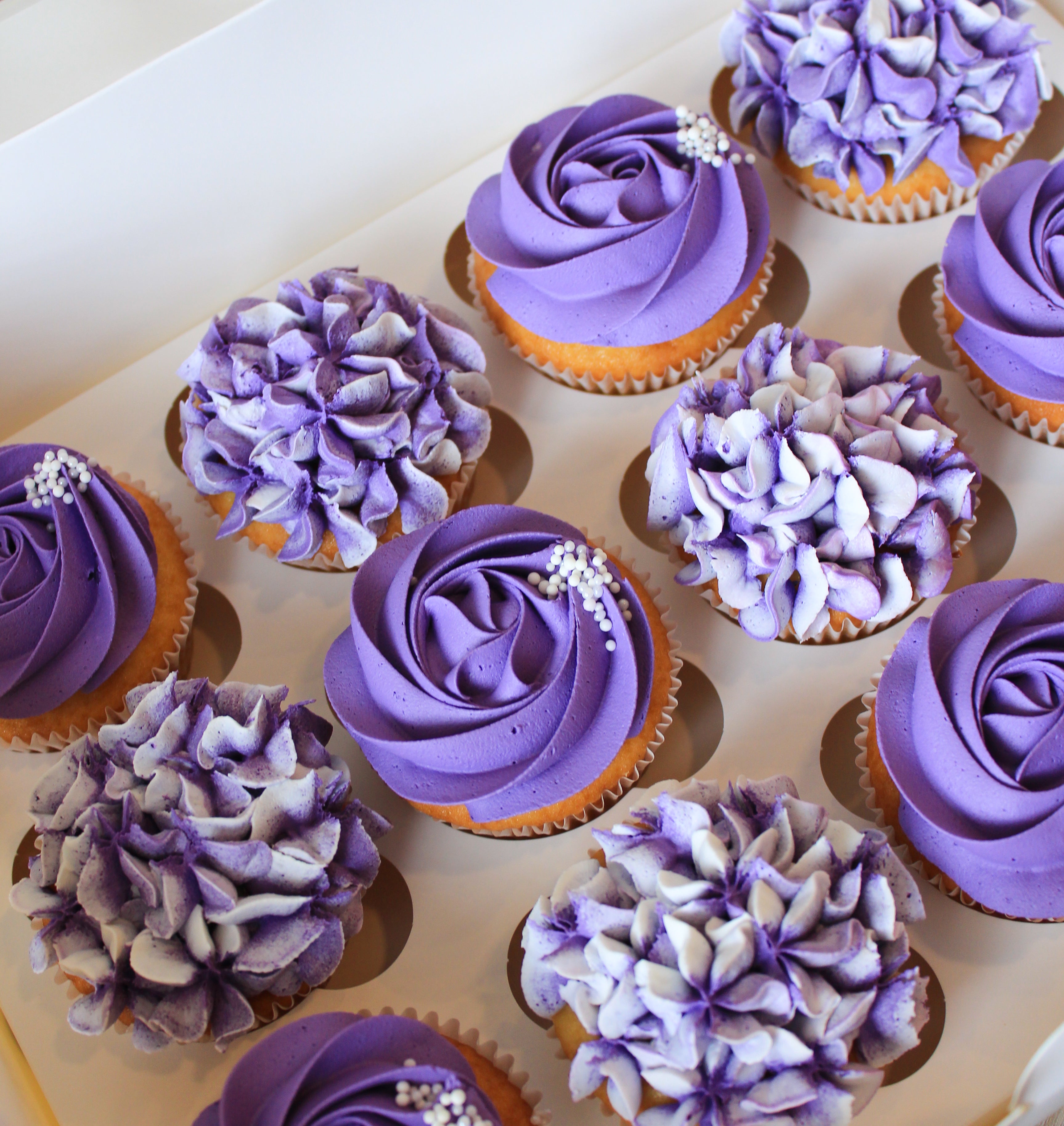 Cupcakes with purple frosting on a baking tray
