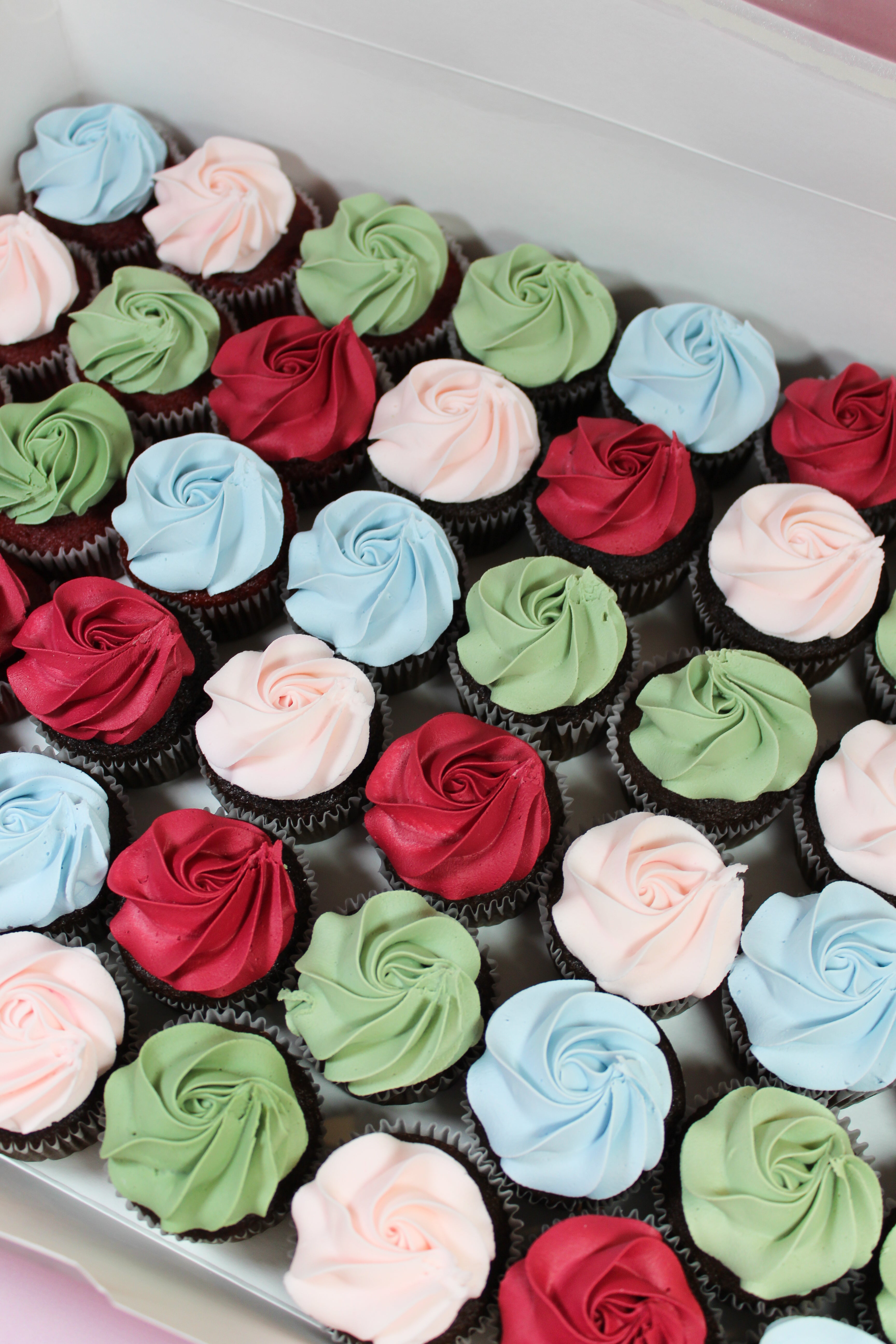 Assorted cupcakes with colorful frosting in a box